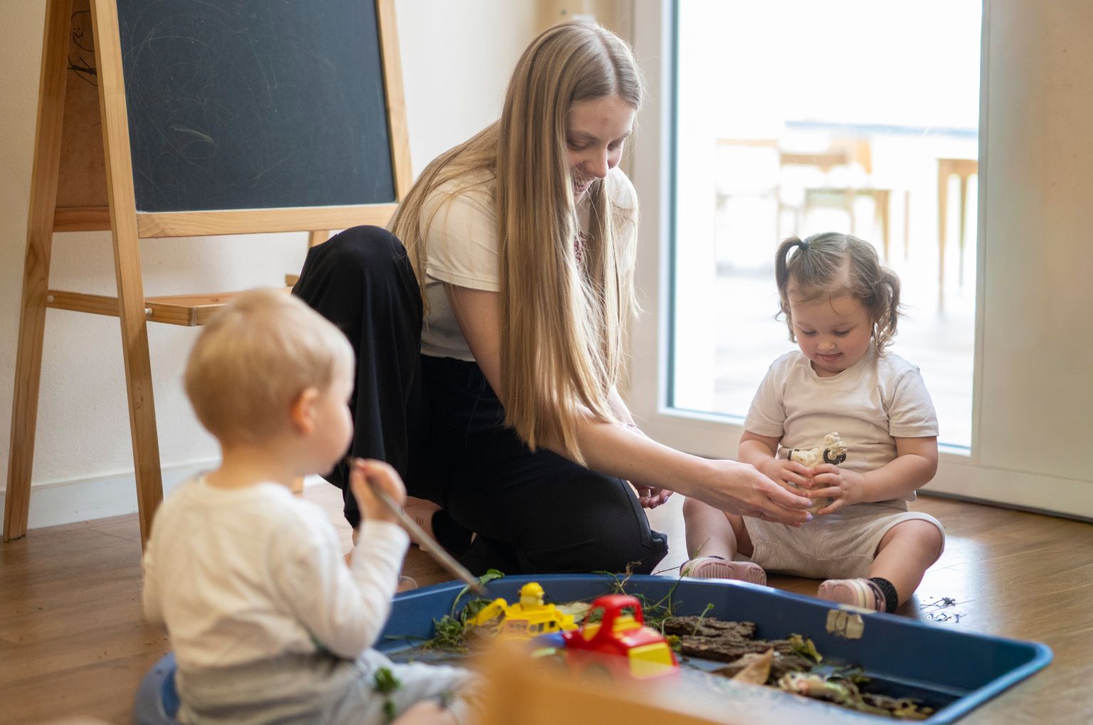 Un’educatrice della BBS Nursery al vassoio sensoriale con i più piccoli