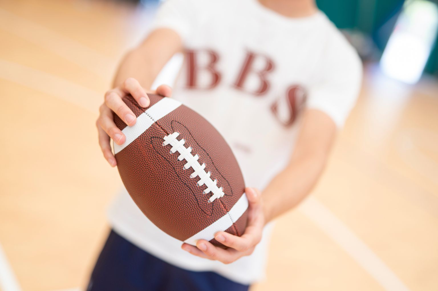 Uno studente BBS con un pallone in mano, dettaglio della tenuta scolastica