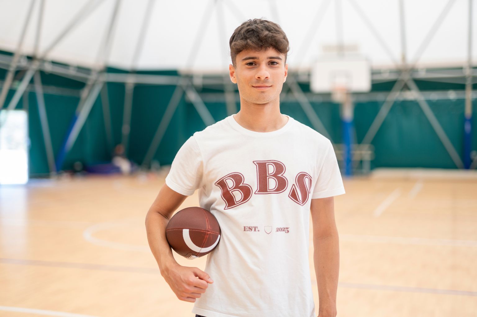 Uno studente BBS con un pallone nella palestra della scuola