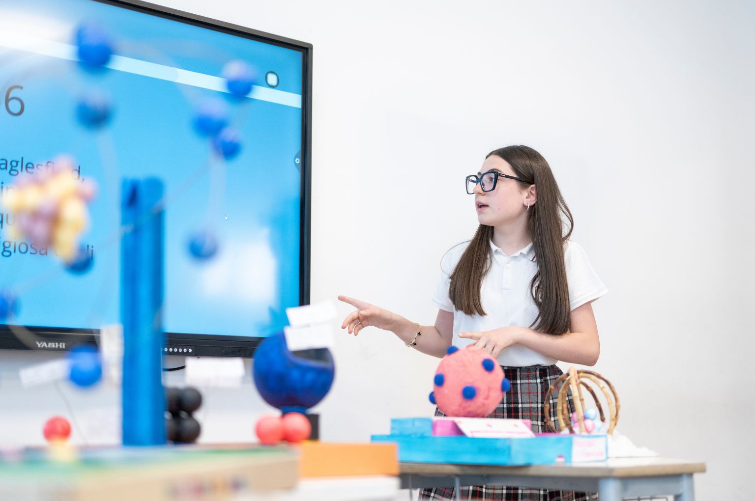Una studentessa BBS che presenta il suo lavoro con modelli molecolari